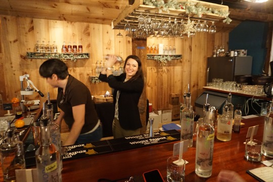 Two women working behind a bar counter, serving drinks and attending to customers.