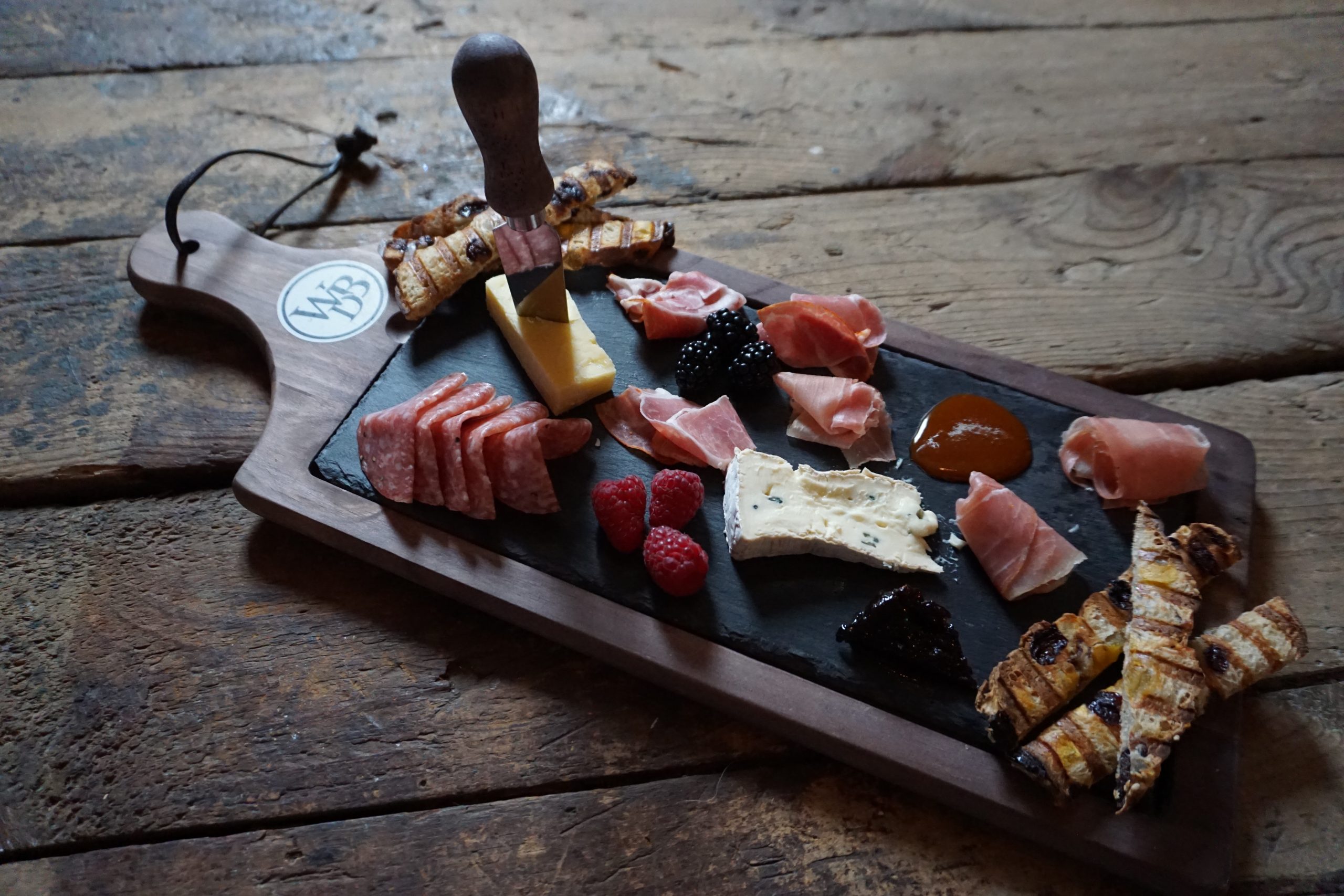 image of the wiggly bridge charcuterie board, containing cheeses, meats, breads and fruit