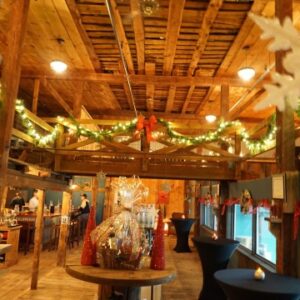 interior shot of the wiggly bridge outfitted for the chirstmas holiday, lights, green garland and red bows covering the walls and banisters