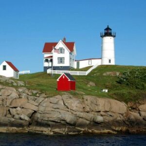 a white light house and a little red shed on an island