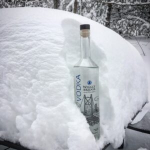 a bottle of wiggly bridge vodka in a pile of snow