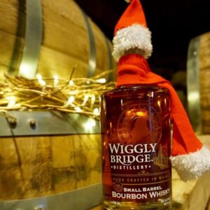 image of a wiggly bridge bourbon whisky wearing a mini santa hat and scarf