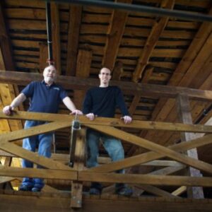 two men standing off a balcony in the distillery