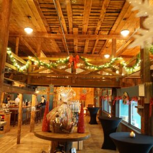 interior shot of the Wiggly Bridge Barn with christmas lights and garland hanging