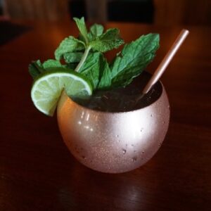 a wiggly harbor mule in a copper cup with mint and lime garnish
